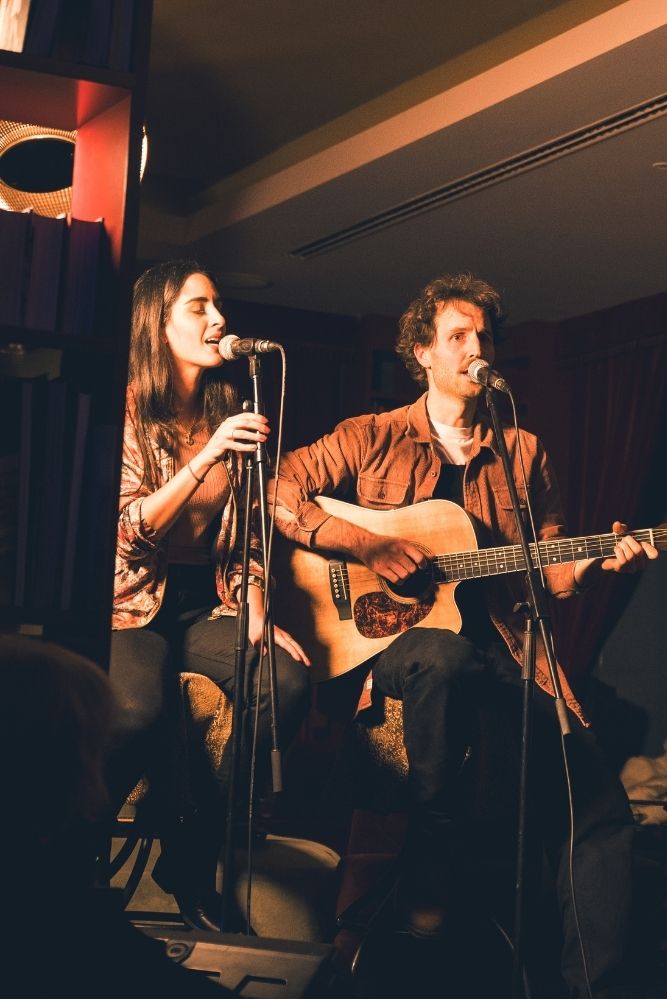 Ein Mann und eine Frau, die gemeinsam vor einem Mikrofon singen und ein Duett zum Besten geben.